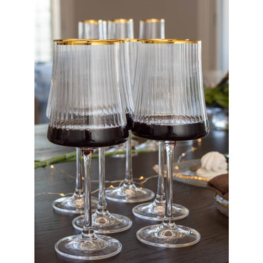 Set of wine glasses with gold rims on a table.