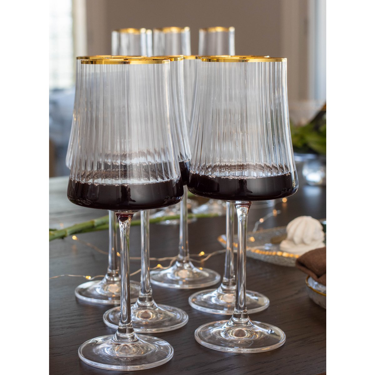 Set of wine glasses with gold rims on a table.
