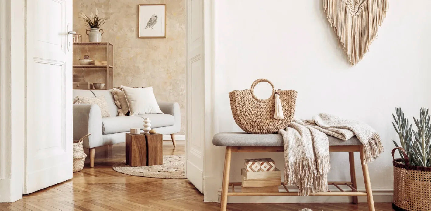Living room with a bench, bag, and decor items on a wooden floor.